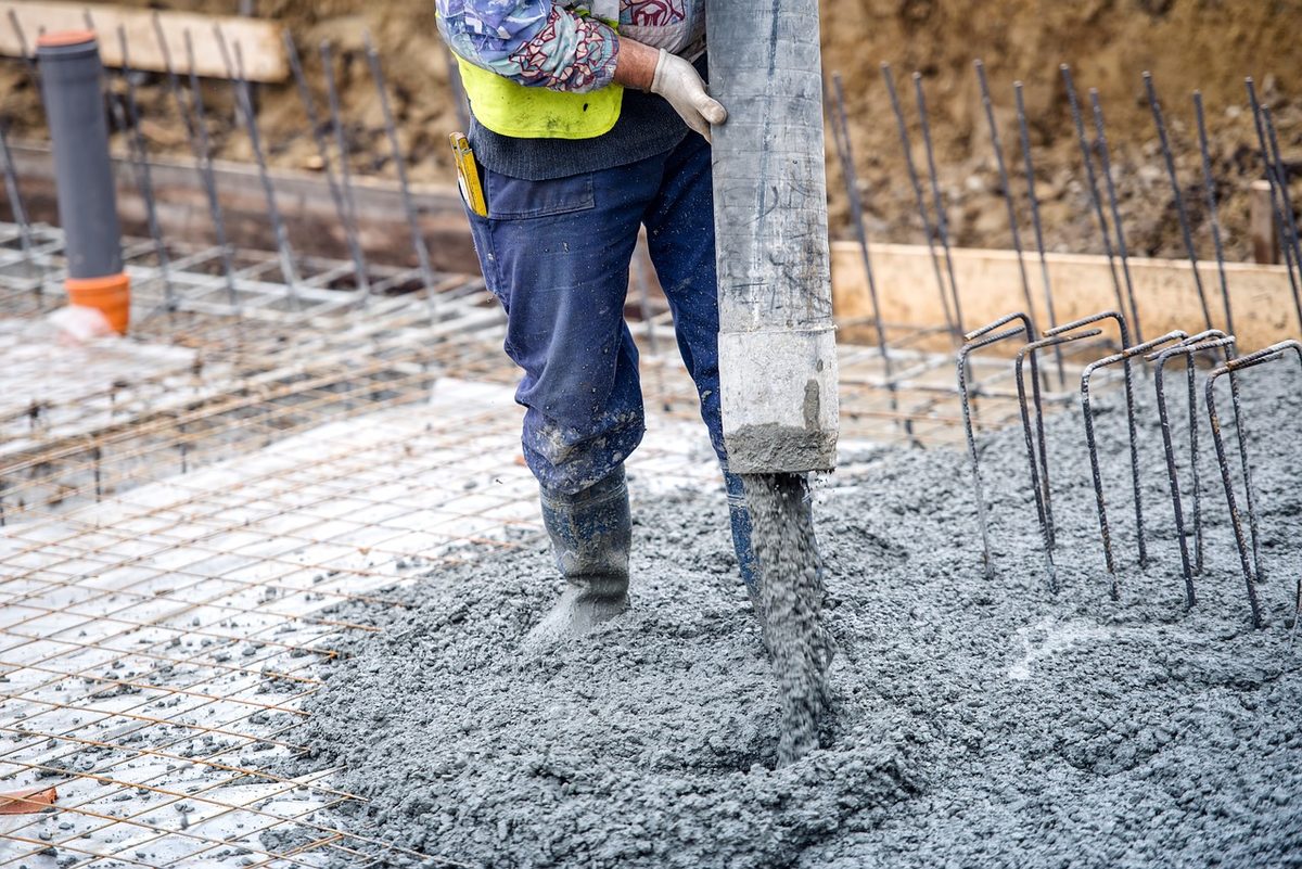 Worker pouring concrete over steel rebar (Florida concrete contractor insurance)