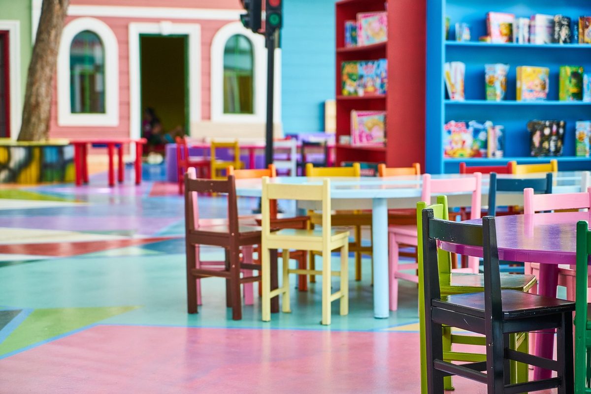 Empty child care classroom with small colorful tables and chairs (Florida day care insurance)