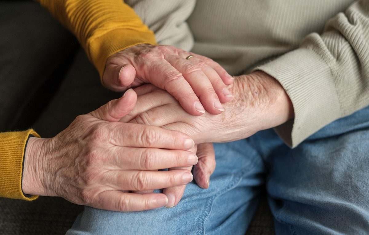 Caregiver holding an older person's hands (Florida home healthcare insurance)