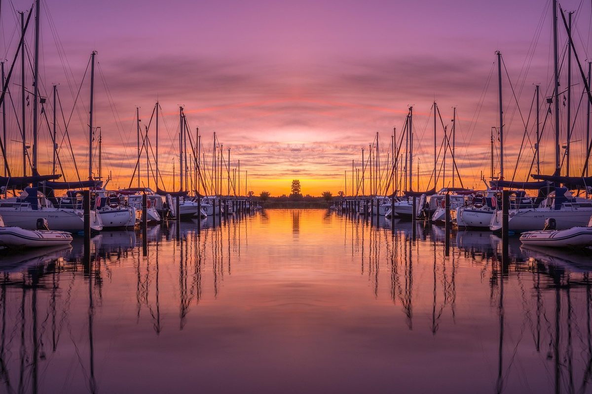 Sailboats docked in a marina at sunset (Florida marina insurance)