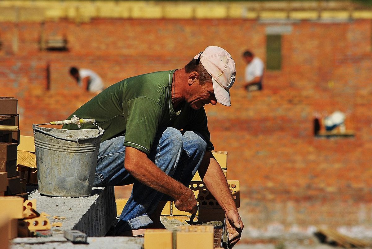 Mason laying bricks on a wall (Florida masonry contractor insurance)