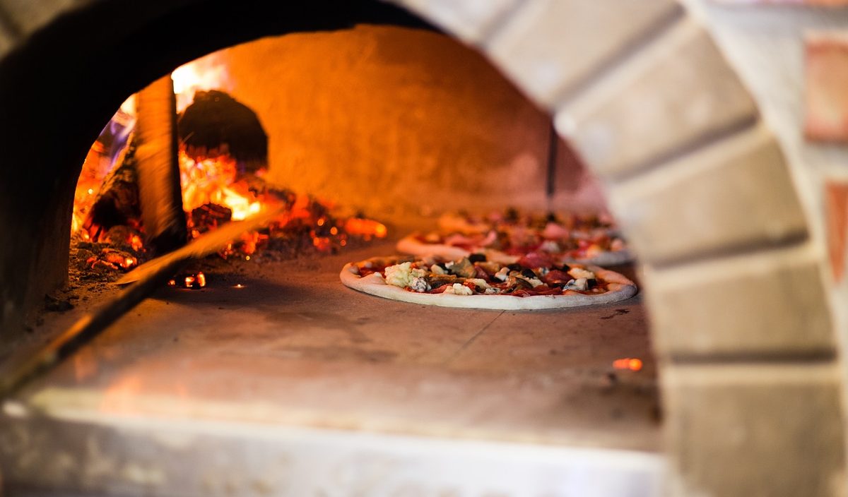 Pizza baking in a brick wood-fired oven (Florida pizzeria insurance)