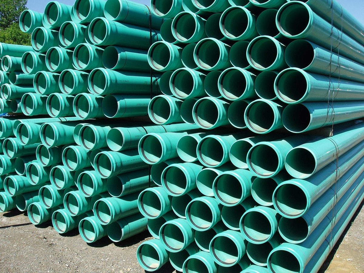 Stacks of green PVC sewer pipe (Florida septic tank contractor insurance)